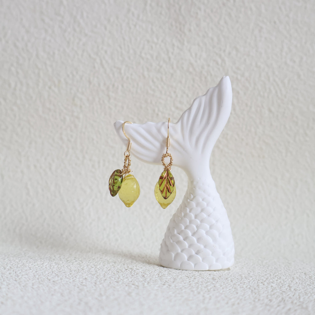 Mermaid tail and earrings on a textured white surface