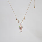 Gold necklace with a floral pendant on a light gray background