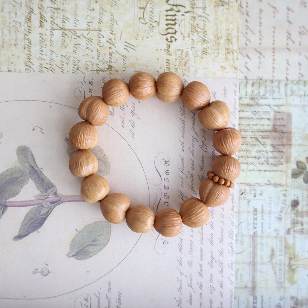 Wooden beaded bracelet on a textured paper background