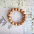 Wooden beaded bracelet on a textured paper background