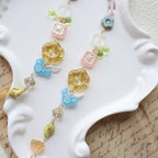 Colorful beaded necklace on a white dish with a textured surface