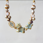Necklace with ceramic beads and floral elements on a light background