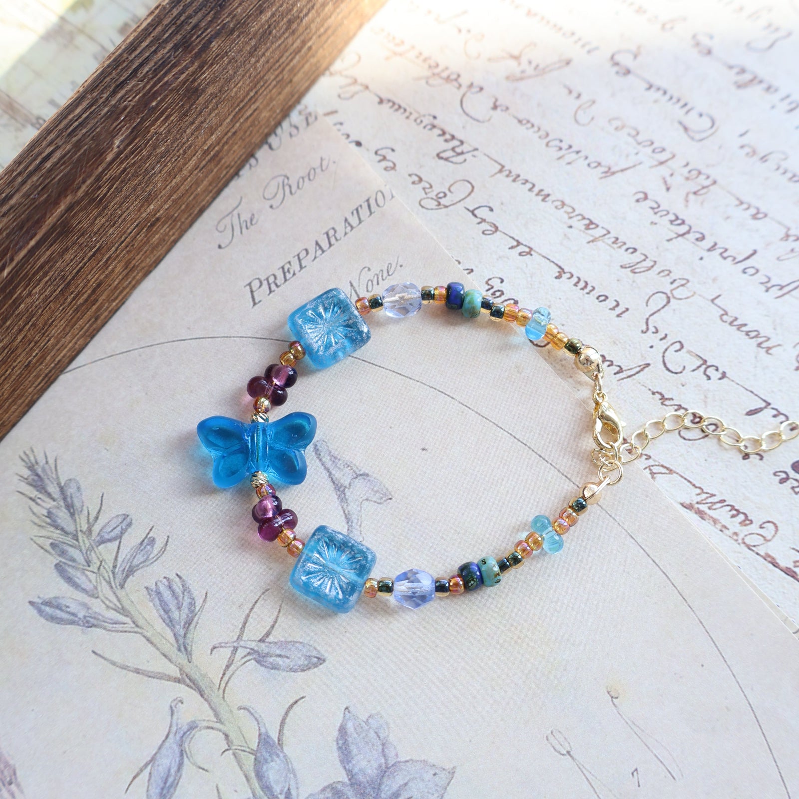 Beaded bracelet with blue flowers on a decorative paper background