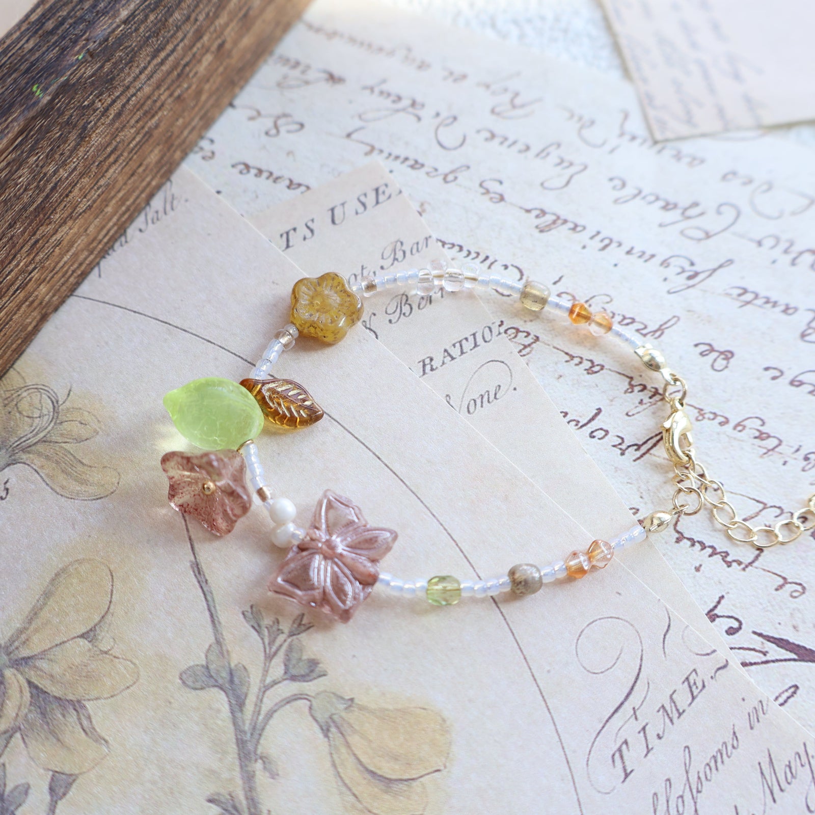 Bracelet with floral beads on a vintage letter background