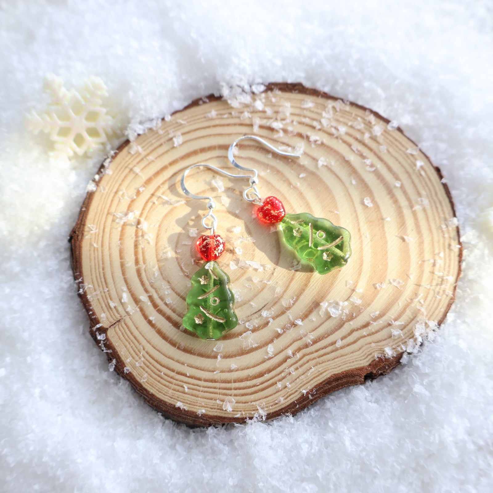 Wooden ornament with holly leaves and berries on a snowy background