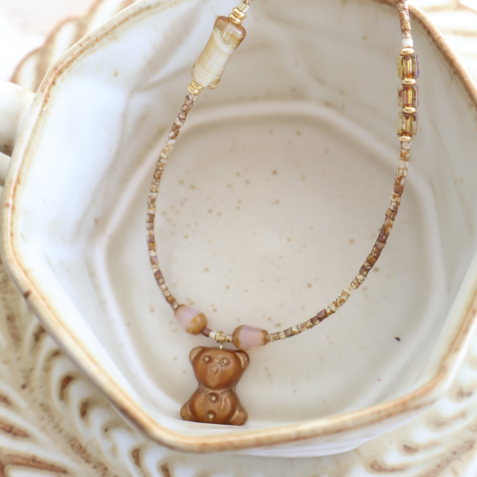 Bracelet with a bow-shaped charm on a textured surface