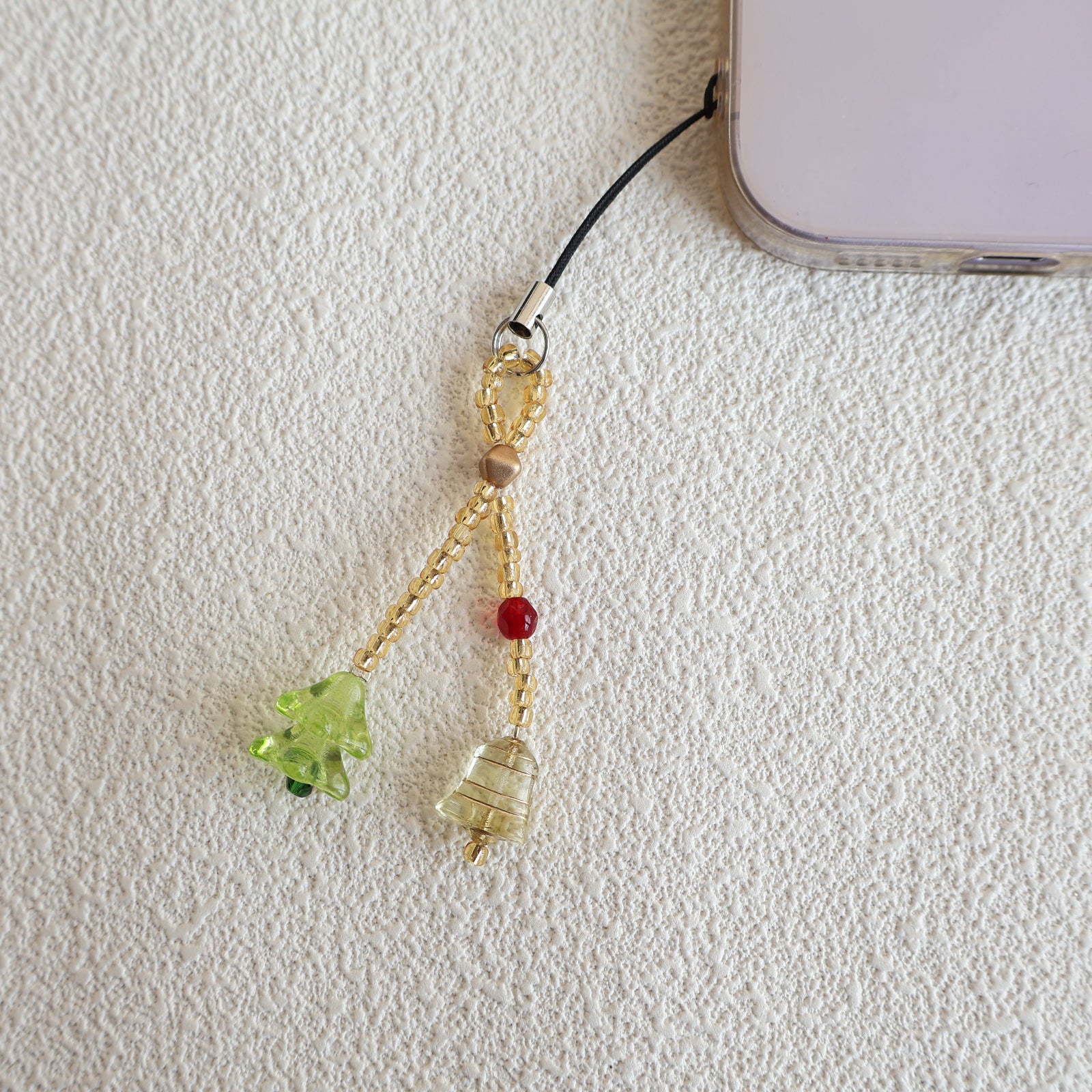 Decorative phone charm with beads on a white background