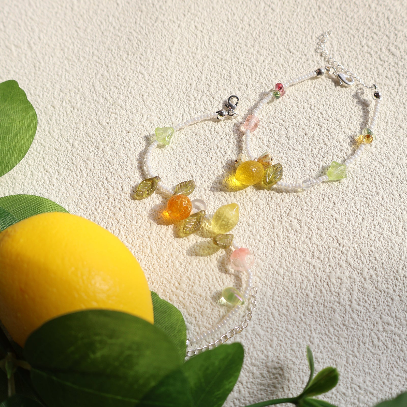 Colorful beaded bracelet on a textured surface with a lemon and leaves in the background