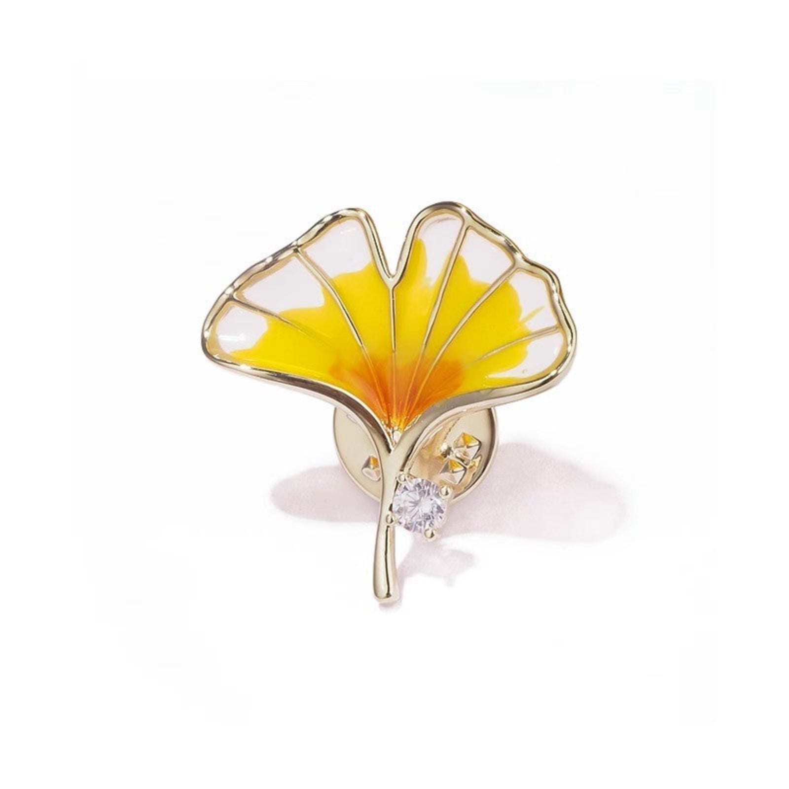 Gold and yellow leaf-shaped brooch on a white background