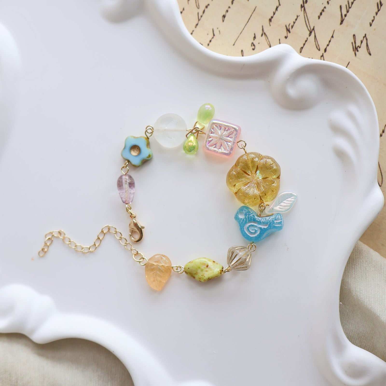 Colorful beaded bracelet on a decorative white plate with a textured background