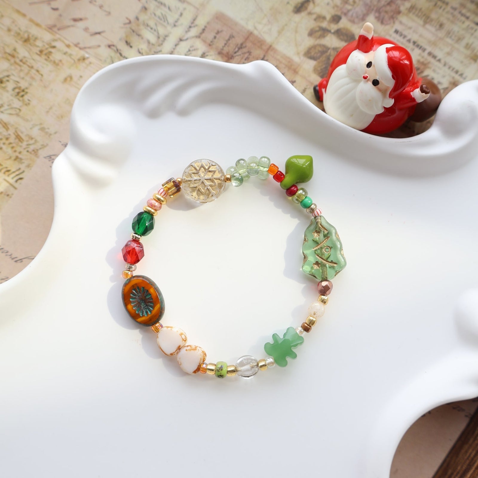 Colorful beaded bracelet on a white dish with a small decorative item in the background