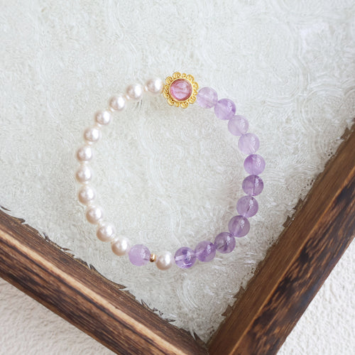 Bracelet with pink and purple beads on a textured white surface