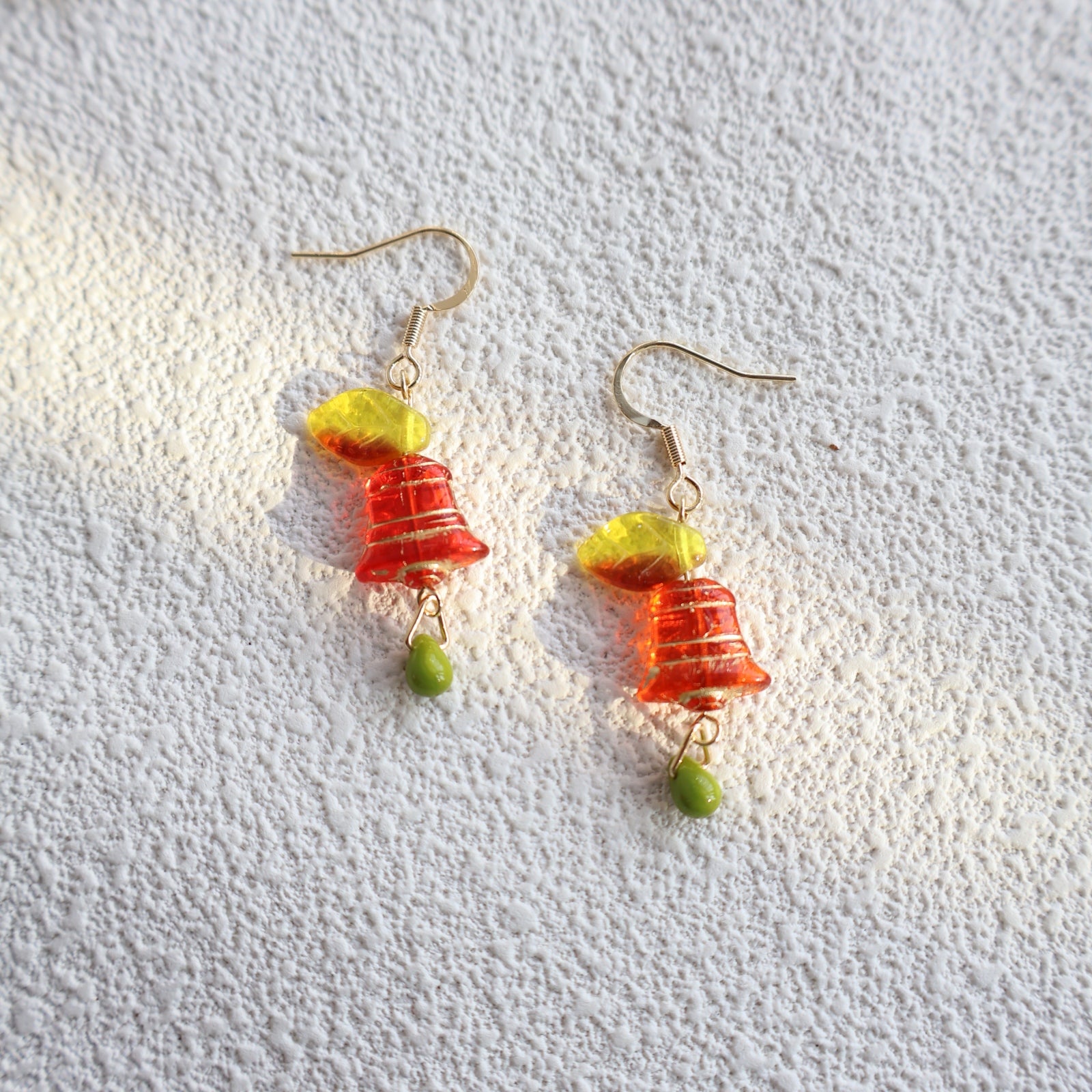 Pair of earrings with colorful beads on a textured white background