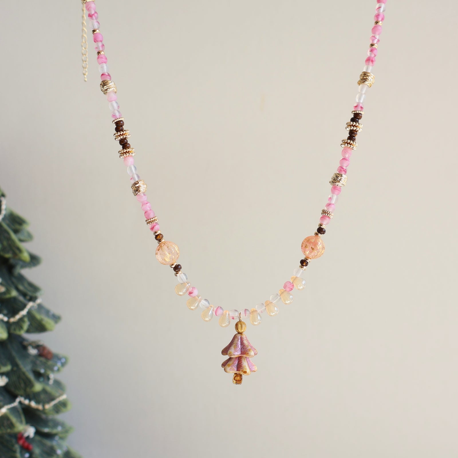 Beaded necklace with pink and gold beads on a light gray background