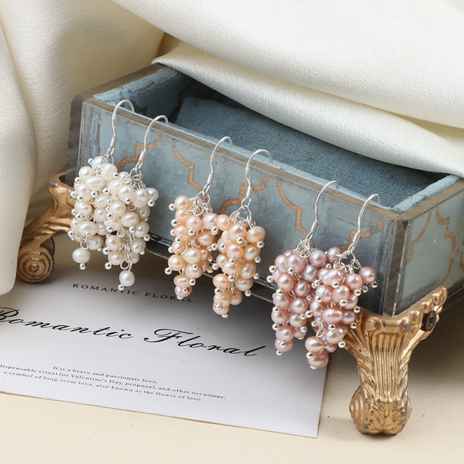 Pearl grape-shaped earrings on a decorative box with 'Romantic Floral' text