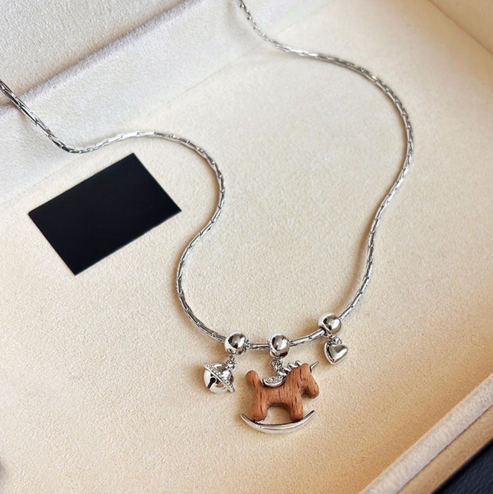 Necklace with a horse-shaped pendant on a beige surface