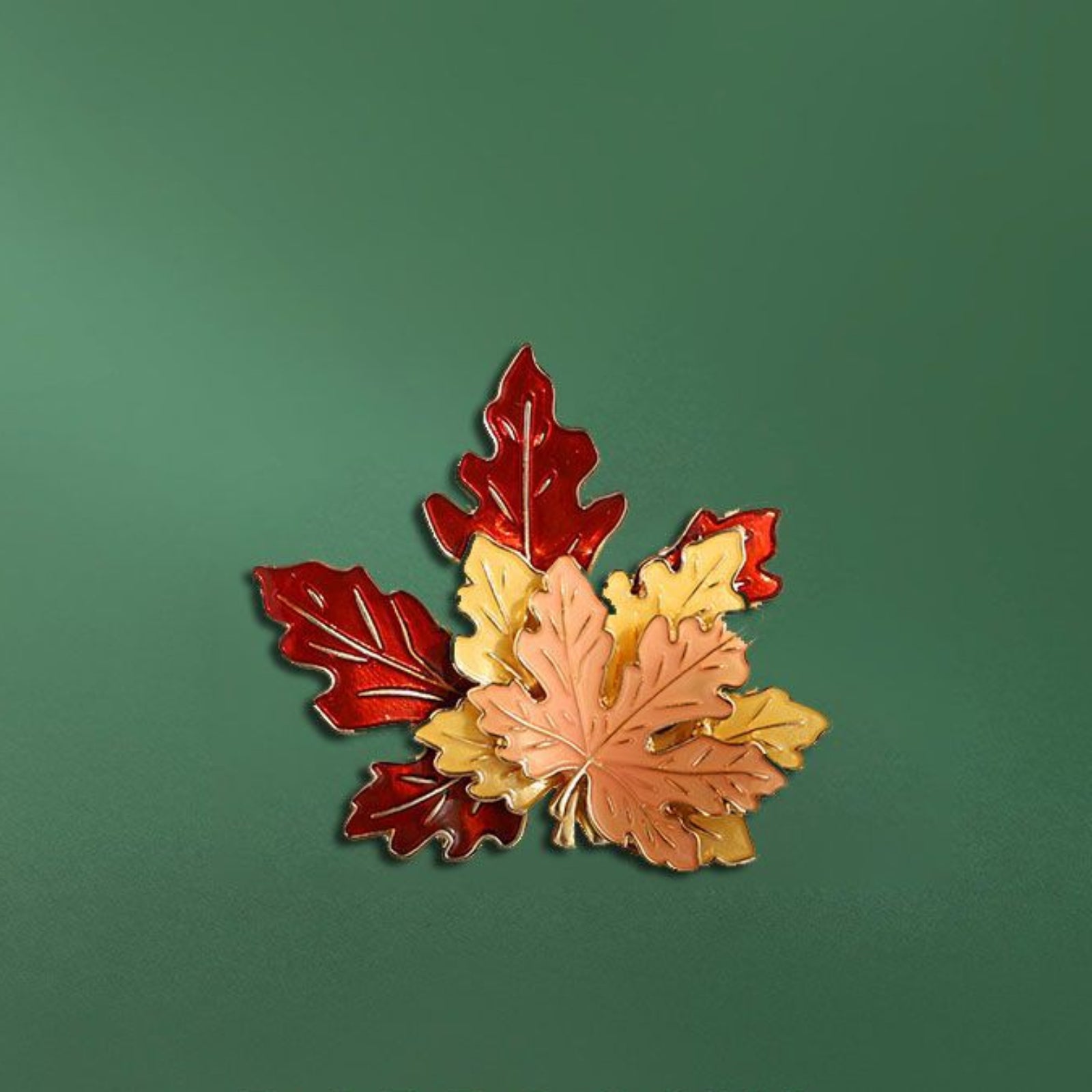 Leaf-shaped brooch with red, orange, and yellow leaves on a green background with 'DABROOCHS' branding.