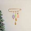 Decorative brooch with colorful charms on a neutral background