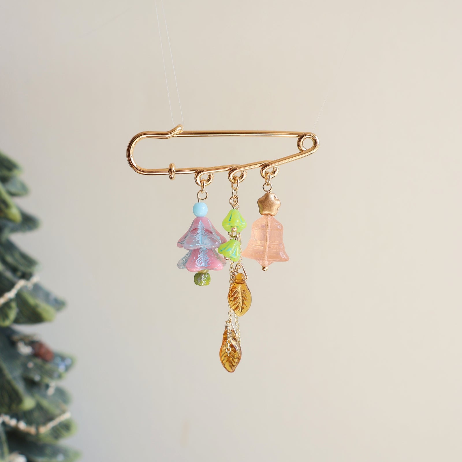 Decorative brooch with colorful charms on a neutral background
