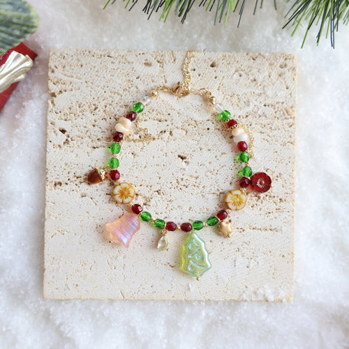 Bracelet with colorful charms on a beige card with a snowy background