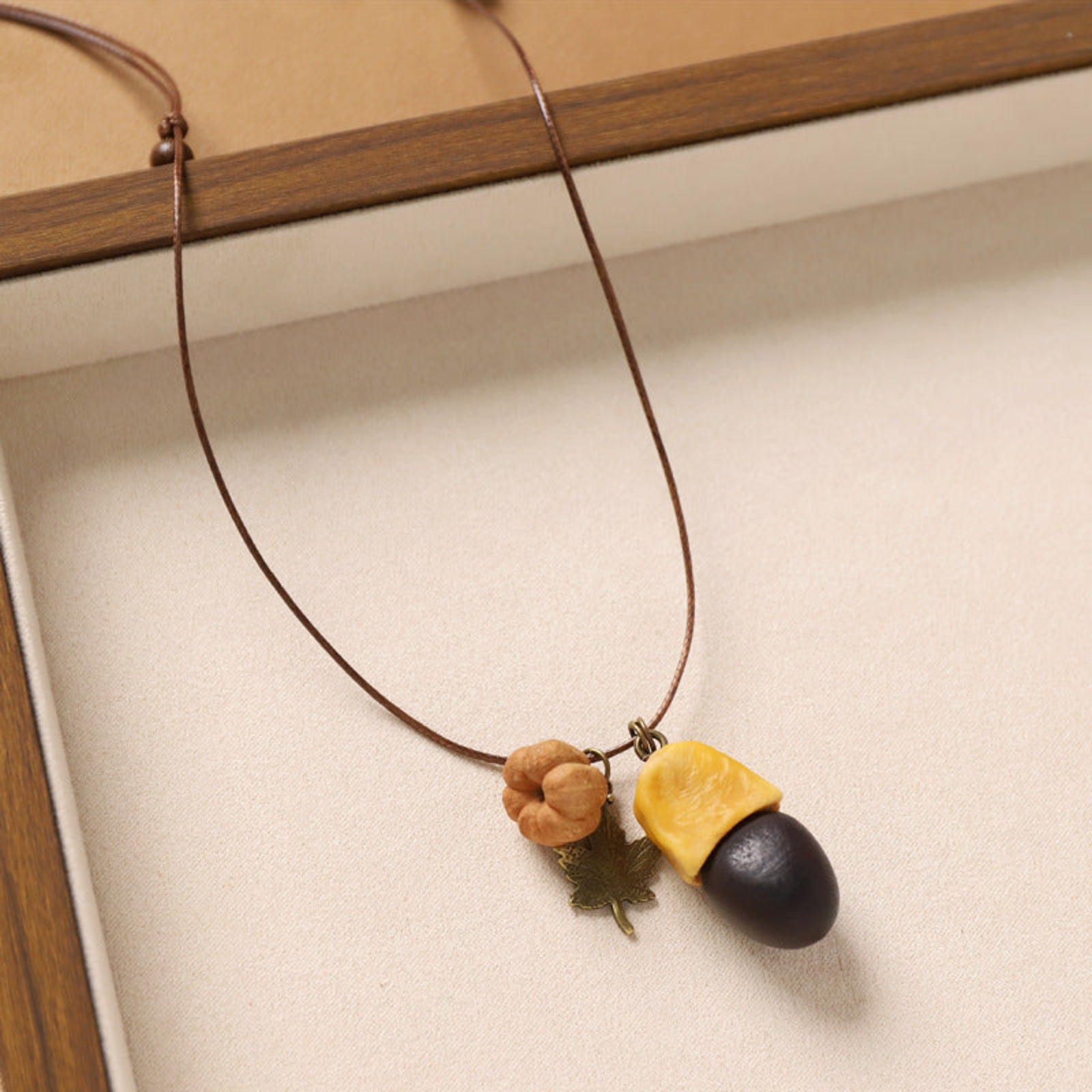 Necklace with acorn-shaped pendants on a neutral background