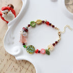 Colorful beaded bracelet on a white dish with a Santa Claus figurine in the background.