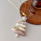 Pearl necklace with gold chain on a white surface
