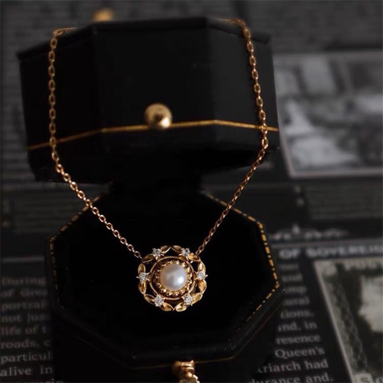 Gold necklace with a pendant on a black stand