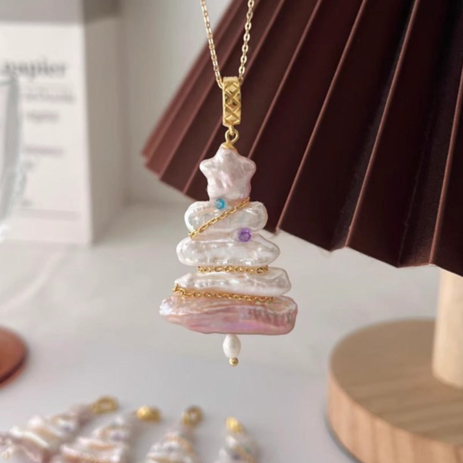 Pearl necklace with a gold chain on a white surface