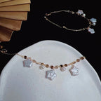 Bracelet with star-shaped charms and pearls on a white plate