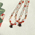 Beaded necklace with red and black accents on a textured white surface
