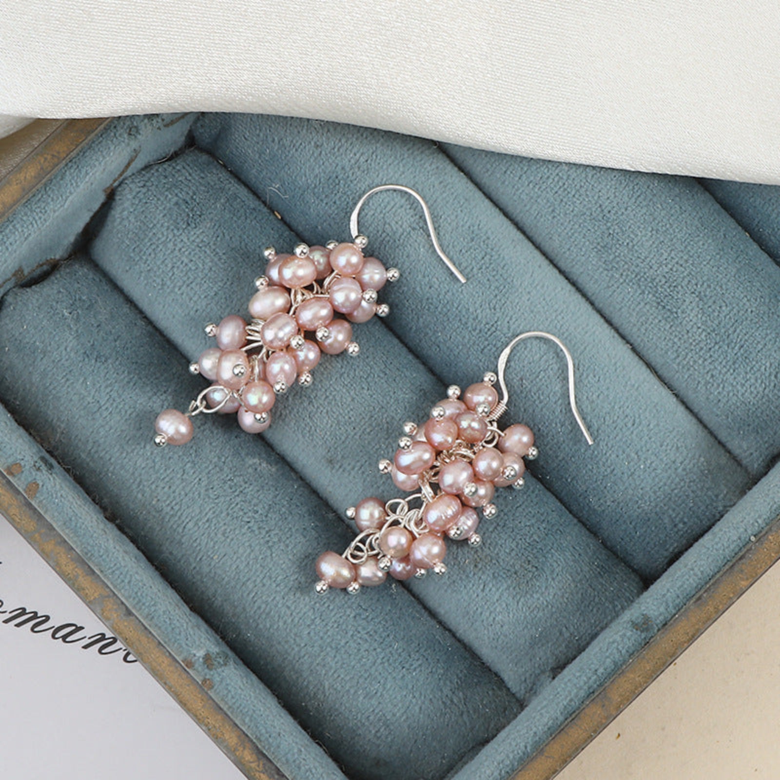 Pair of pink pearl earrings in a jewelry box