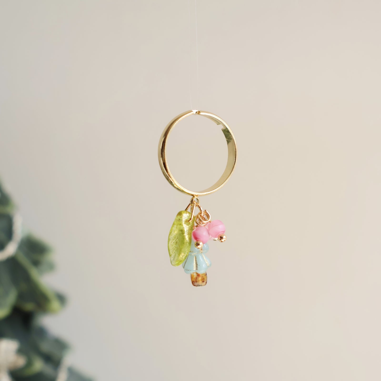 Gold hoop earring with colorful beads on a light background