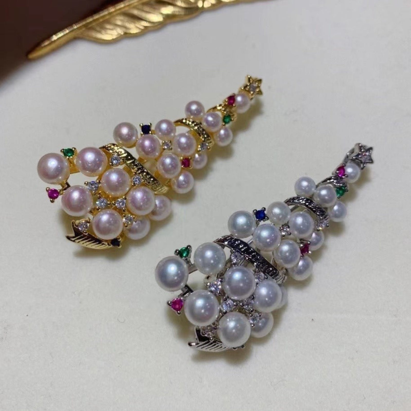 Pair of pearl earrings with gemstones on a light background