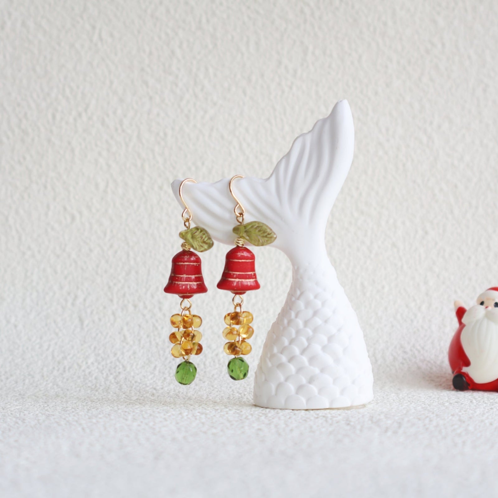 Colorful earrings on a white decorative fish stand with a light background
